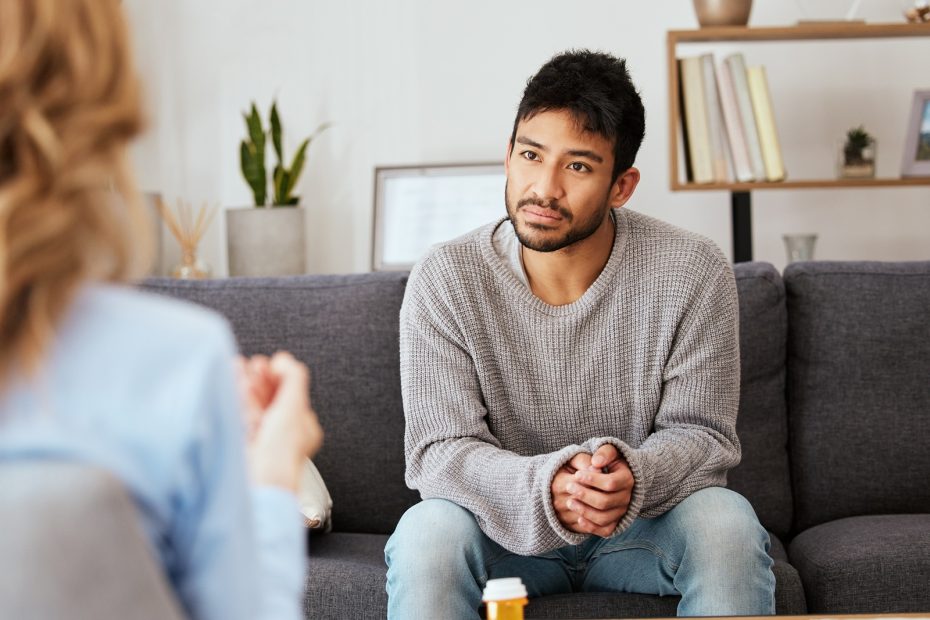 Shot of a young man having a therapeutic session with a psychologist.