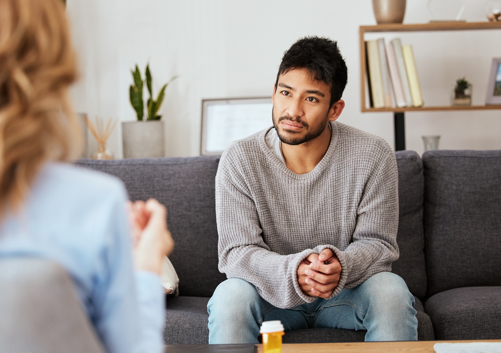 Shot of a young man having a therapeutic session with a psychologist.