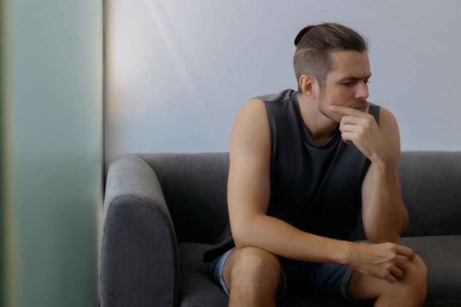 Gay Substance Abuse Pensive mature caucasian male sitting on sofa in thought