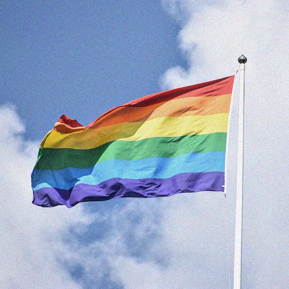 A pride flag waving in the sky.